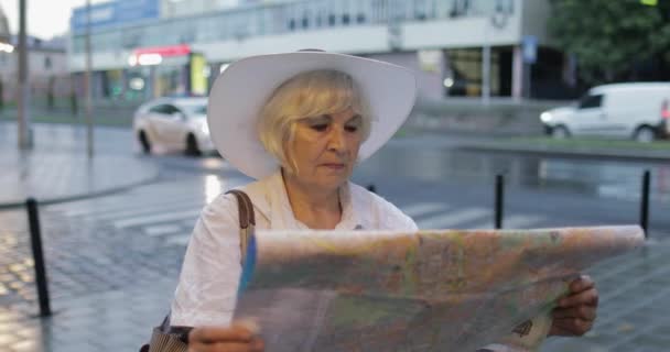 Turista senior explorando la ciudad con un mapa en las manos. Buscando la ruta — Vídeos de Stock