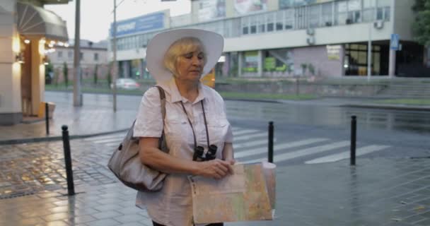 Senior kvinnlig turist utforska staden med en karta i händerna. Letar du efter rutten — Stockvideo