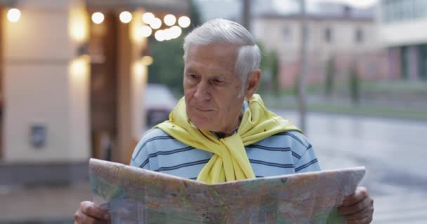 Senior turista masculino explorando la ciudad con un mapa en las manos y buscando la ruta — Vídeos de Stock