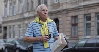 Bir harita ile şehir keşfetmek kıdemli turist. Dürbünle bakmak