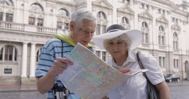 高级男性游客用手中的地图向妇女询问城镇的路线 — 图库视频影像