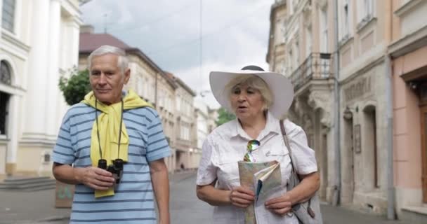 Üst düzey erkek ve kadın turistler yol arıyor elinde bir harita ile yürüyüş — Stok video