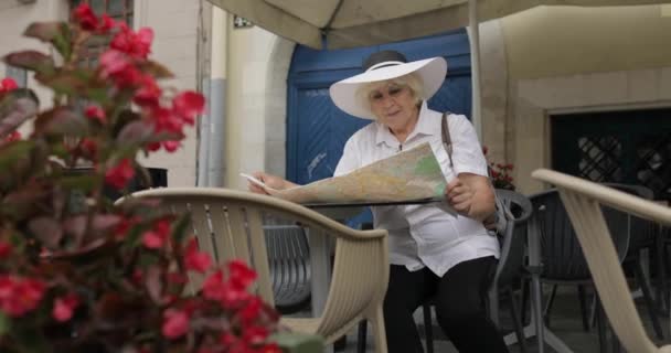 Senior mujer turística explorar la ciudad Lviv, Ucrania mapa en la cafetería — Vídeos de Stock