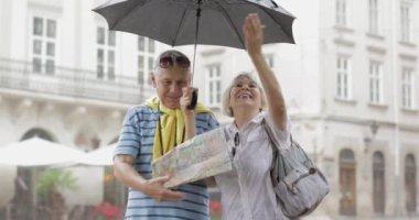 Mutlu üst düzey turistler şehir merkezinde durmak ve Lviv yağmurlu havanın tadını çıkarın