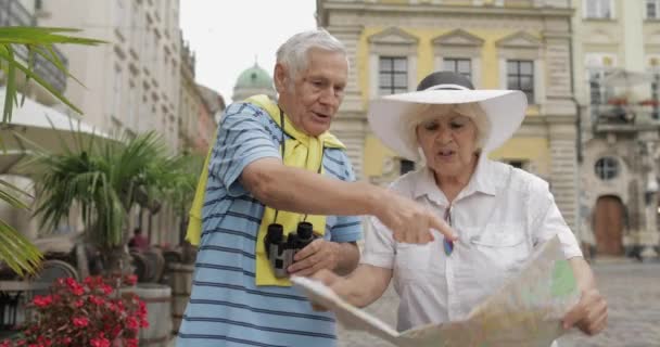 Starsi dwaj turyści mający dyskusję na temat planowania trasy turystycznej we Lwowie — Wideo stockowe