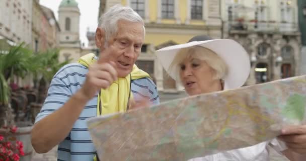 Senior två turister med diskussion om planering turistrutten i Lviv — Stockvideo