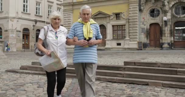 Senior manliga och kvinnliga turister gå med en karta i händerna söker rutt — Stockvideo
