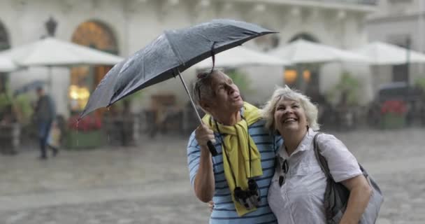 Felices turistas senior están en el centro y disfrutan del clima lluvioso en Lviv — Vídeos de Stock