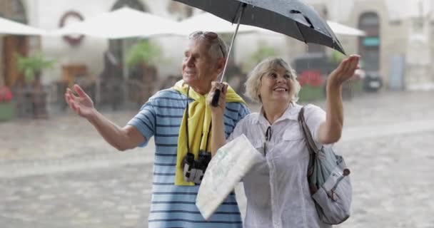 Szczęśliwi starsi turyści stoją w centrum miasta i cieszyć się deszczową pogodą we Lwowie — Wideo stockowe