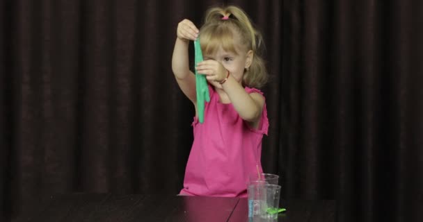 Yeşil balçık yaparken eğlenen çocuk. El yapımı oyuncak balçıkile oynayan çocuk — Stok video