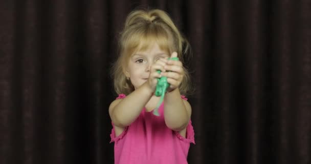 Παιδί που διασκεδάζει φτιάχνοντας πράσινη γλίτσα. Παιδί παίζοντας με το χέρι φτιαγμένο παιχνίδι λάσπη — Αρχείο Βίντεο