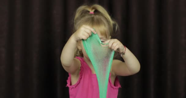 L'enfant s'amuse à faire de la boue verte. Enfant jouer avec la main jouet boue — Video