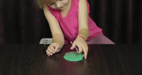 Yeşil balçık yaparken eğlenen çocuk. El yapımı oyuncak balçıkile oynayan çocuk — Stok video