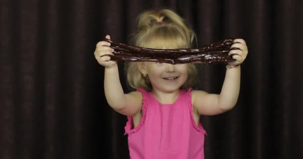 Kinder haben Spaß dabei, braunen Schleim zu machen. Kind spielt mit handgemachtem Spielzeugschleim — Stockvideo