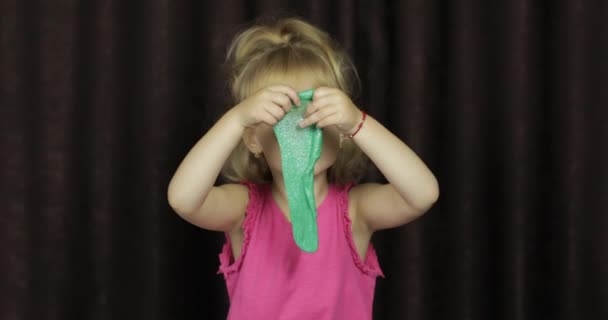 Child having fun making green slime. Kid playing with hand made toy slime — Stock Video