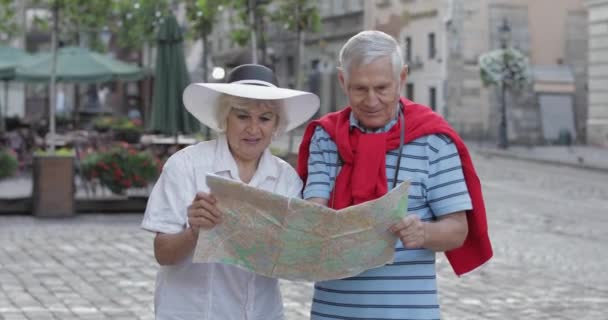 Vysocí mužští a samičí turisté, kteří stojí s mapou v rukou hledajících trasu — Stock video