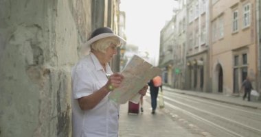 Elinde bir harita ile şehir keşfetmek Kıdemli kadın turist. Rotayı arıyorum