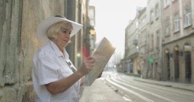 Elinde bir harita ile şehir keşfetmek Kıdemli kadın turist. Rotayı arıyorum