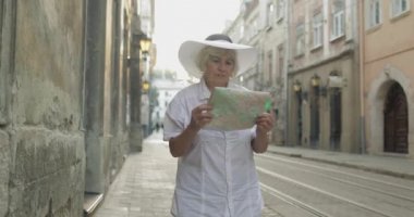 Elinde bir harita ile şehir keşfetmek Kıdemli kadın turist. Rotayı arıyorum