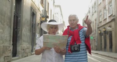 Üst düzey erkek ve kadın turistler yol arıyor elinde bir harita ile yürüyüş