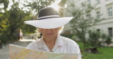 Elinde bir harita ile şehir keşfetmek Kıdemli kadın turist. Rotayı arıyorum