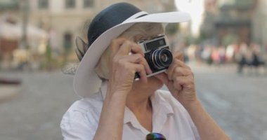 Büyük kadın turist şehir keşfetmek ve retro fotoğraf makinesi ile bir fotoğraf yapar