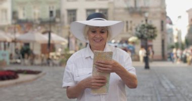 Elinde bir harita ile şehir keşfetmek Kıdemli kadın turist. Rotayı arıyorum