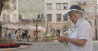 Elinde bir harita ile şehir keşfetmek Kıdemli kadın turist. Rotayı arıyorum