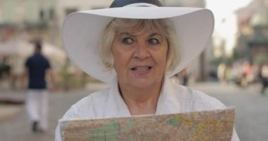 Elinde bir harita ile şehir keşfetmek Kıdemli kadın turist. Rotayı arıyorum