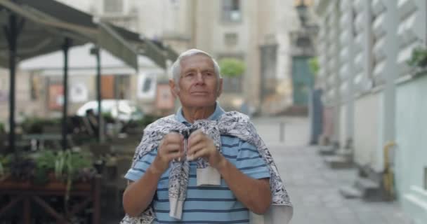 마을을 탐험 하는 노인 관광. 쌍안경으로 찾고 있습니다. 여행 리비우, 우크라이나 — 비디오