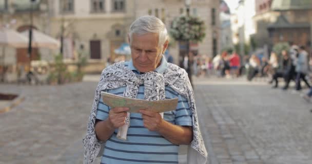 Γηραιότερος άντρας τουρίστας εξερευνώντας την πόλη με ένα χάρτη στα χέρια. Ψάχνοντας για τη διαδρομή — Αρχείο Βίντεο