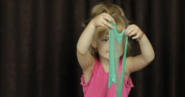 Kind plezier maken van groene slijm. Kid spelen met handgemaakt speelgoed slime — Stockfoto