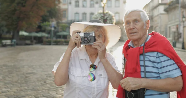 Senior férfi és női turisták teszi a fotót utazás közben a Lviv, Ukrajna — Stock Fotó
