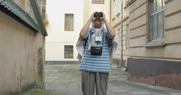 Touriste senior explorant la ville. Je regarde dans les jumelles. Voyage Lviv, Ukraine — Photo