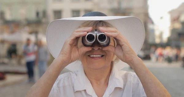 Senior Kvinna turist utforska staden. Titta i kikare. Travel Lviv, Ukraina — Stockfoto