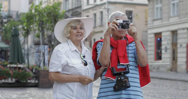 Senior male and female tourists makes a photo while traveling in Lviv, Ukraine Stock Image