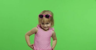 Pembe mayo giyen çocuk spor yapıyor, kız spor yapıyor ve dans ediyor.