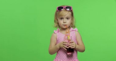 Pembe mayogiyen çocuk, saman içen meyve suyu kokteyli içer. Renk Anahtarı