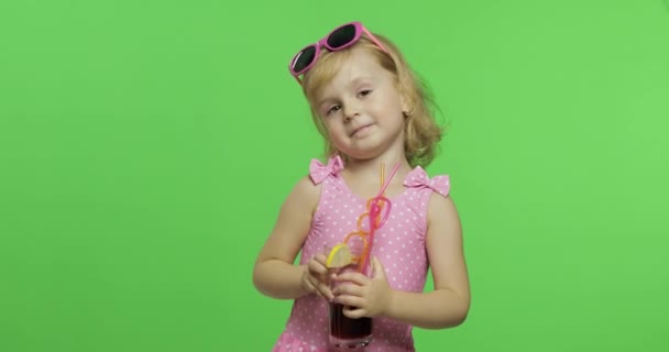 Bambino in costume da bagno rosa beve succo di cocktail con paglia da bere. Chiave cromatica — Video Stock