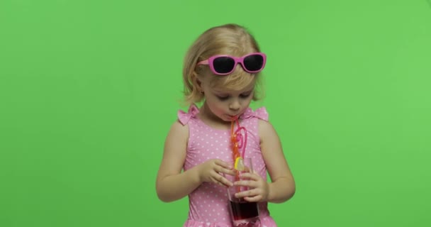 Niño en traje de baño rosa bebe jugo cóctel con paja para beber. Clave de croma — Vídeo de stock