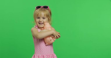 Pembe mayogiyen çocuk oyuncak bir domuzla oynuyor. Renk Anahtarı