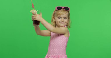 Pembe mayo giyen çocuk, saman içen meyve suyu kokteyli tutar. Renk Anahtarı