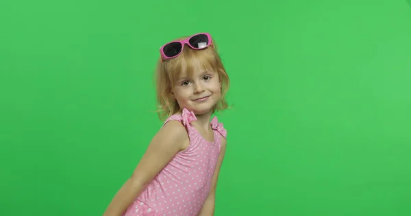 Niña feliz y bonita en traje de baño rosa y gafas de sol. Vacaciones. Clave de croma — Foto de Stock