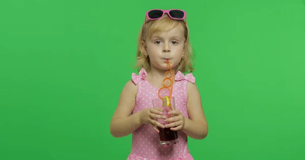 Barn i rosa baddräkt drycker juice cocktail med dricks halm. Chroma Key — Stockfoto