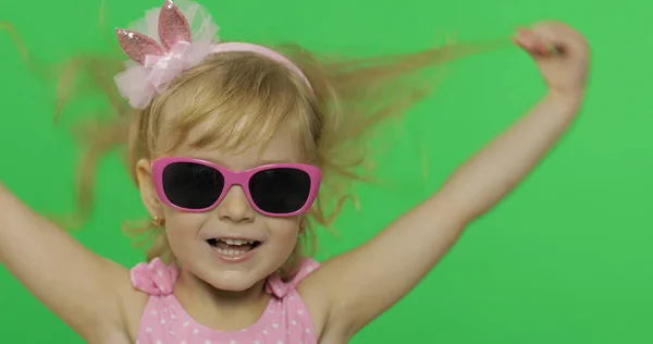 Ganska barn känslomässigt gör ansikten och leende i rosa baddräkt och solglasögon — Stockfoto