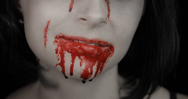 Кровавый рот и зубы девушки. Вампирский макияж на Хэллоуин с капельной кровью
