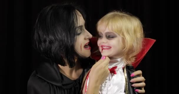 Женщина и ребенок Дракула. Хэллоуинский макияж вампира. Ребенок с кровью на лице — стоковое видео