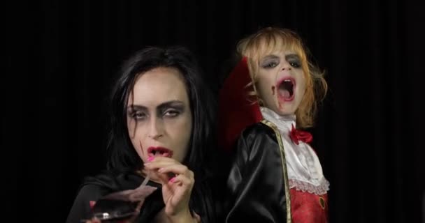 Nő és gyerek Drakula. Halloween vámpír smink. Vér van az arcán. — Stock videók