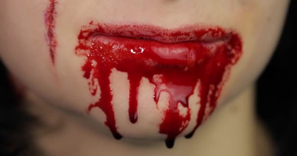 Maldita boca y dientes de chica. Maquillaje de Halloween vampiro con sangre goteando — Vídeo de stock