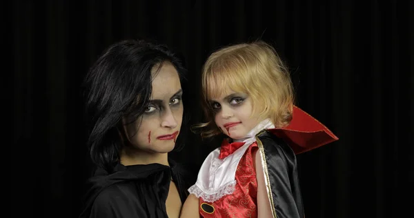 Nő és gyerek Drakula. Halloween vámpír smink. Vér van az arcán. — Stock Fotó